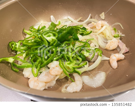 A frying pan with peppers, onions and shrimp. A frying pan with peppers, onions and shrimp. 135851482