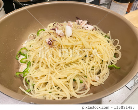 在煎鍋裡烹調魷魚辣椒海鮮意麵。 135851483