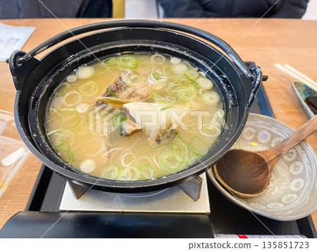 Fish soup in a clay pot. Miso soup with fish heads. 135851723