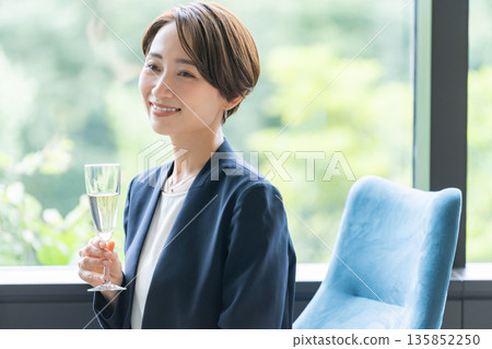 Businessmen and women drinking alcohol at a dinner party 135852250