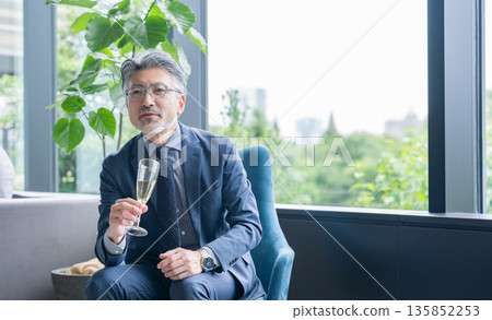 Middle-aged businessman drinking alcohol at a dinner party 135852253