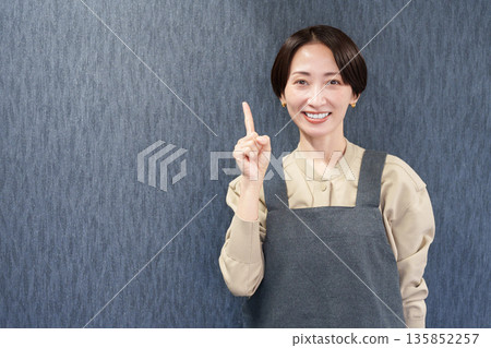 一位穿著圍裙的女店員指著 135852257