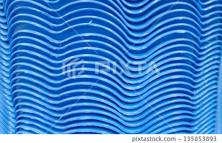 Abstract Background of Stacked Blue Plastic Chairs with Wavy Edge Texture 135853893
