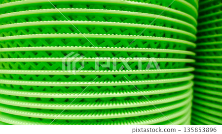 Stack of Green Plastic Drainage Trays or Floor Mats with Grid Texture 135853896