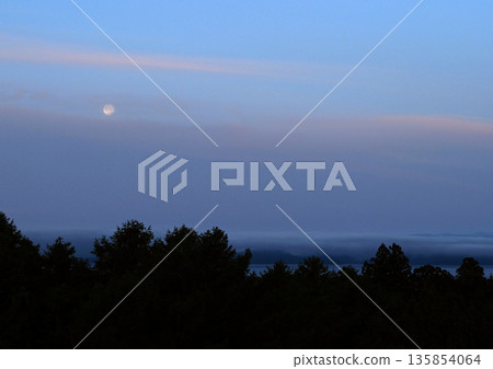 黎明前，晨曦中殘留的粉紅色雲朵和皎潔的白月交相輝映，景色迷人。 135854064