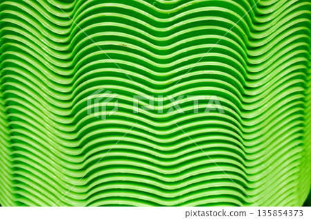 Stacked Green Plastic Plates with Wavy Texture Pattern Background Stacked Green Plastic Plates with Wavy Texture Pattern Background 135854373