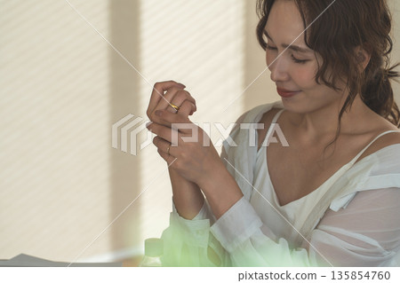 Japanese women applying hand cream to the back of their hands (skin care) 135854760