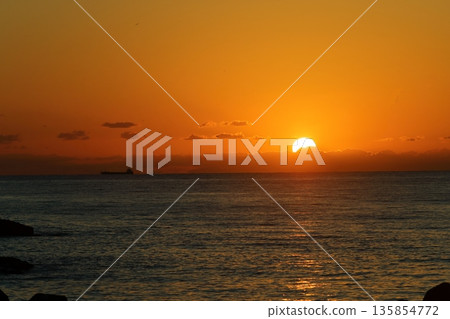 夕陽映照著大海和橘色的天空 夕陽映照著大海和橘色的天空 135854772