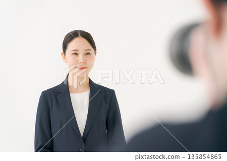 A woman in a suit being photographed A woman in a suit being photographed 135854865