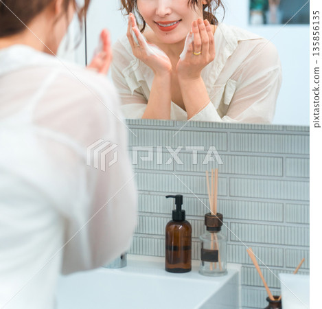 Asian housewife woman washing her face in the bathroom (makeup remover, cleanser, foam face wash) 135856135