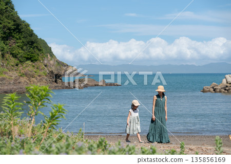 Parent and child walking on the beach 135856169