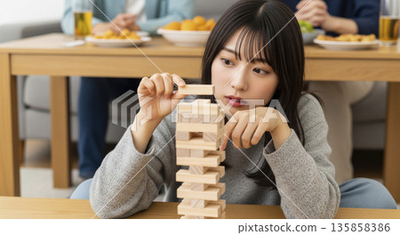 Pulling out a wooden block from the balance tower 135858386