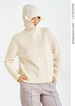 Warm weather wear for cold days in urban setting featuring a woman in a knitted sweater and hat Warm weather wear for cold days in urban setting featuring a woman in a knitted sweater and hat 135858448
