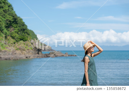 一個女人在沙灘上散步 135858672