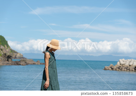 A woman walking along the beach A woman walking along the beach 135858673