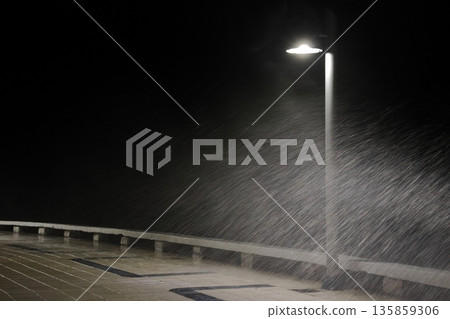 A wave splashing over a streetlamp. 135859306