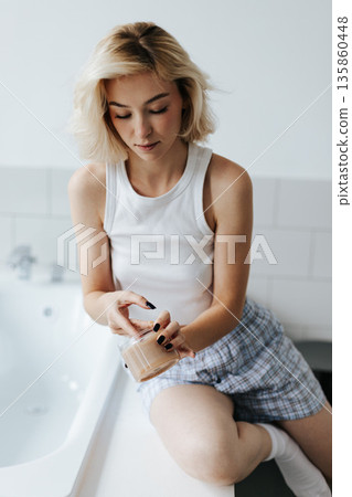 Woman Get Cosmetic Body Scrub From Jar Sitting On Bath In Bathroom 135860448