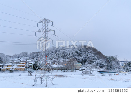 Snow-covered suburban streets and power transmission towers Japanese infrastructure scenery in winter Snow-covered suburban streets and power transmission towers Japanese infrastructure scenery in winter 135861362
