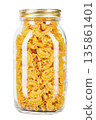 Dried macaroni cockerel scallops. Pasta in a glass jar isolated on a white background. 135861401