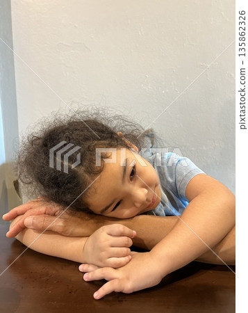 Portrait of a beautiful Asian little girl with curly hair in a blue shirt Portrait of a beautiful Asian little girl with curly hair in a blue shirt 135862326