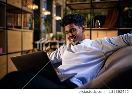 Young man using laptop in modern coworking environment. 135862455