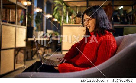Female professional working on laptop in modern coworking space. Female professional working on laptop in modern coworking space. 135862462