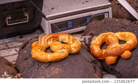 Golden pretzels on rustic dark sourdough loaves Golden pretzels on rustic dark sourdough loaves 135862677