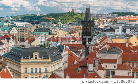 Aerial view of the traditional red roofs of the city of Prague, Czech Republic with the Powder tower and Vitkov Hill in the distance timelapse. Aerial view of the traditional red roofs of the city of Prague, Czech Republic with the Powder tower and Vitkov Hill in the distance timelapse. 135863078