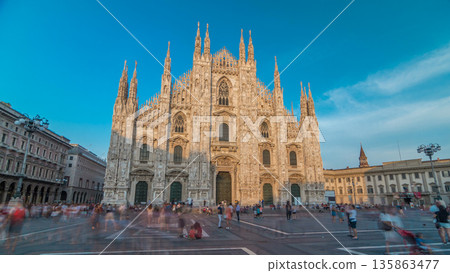 The Duomo cathedral timelapse hyperlapse at sunset. Front view with people walking on square 135863477