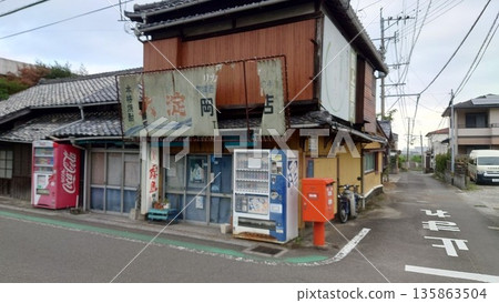 A quiet street corner in Japan, lined with old-fashioned shops and vending machines A quiet street corner in Japan, lined with old-fashioned shops and vending machines 135863504