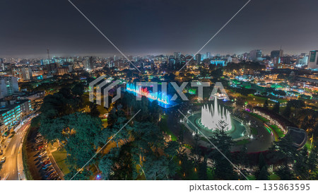 Aerial view to Park of the Reserve with colorful magic water circuit biggest fountain complex night timelapse 135863595