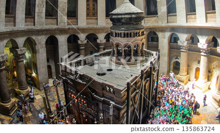 Crowd of people and ray of sun from dome in the Church of the Holy Sepulcher timelapse. 135863724