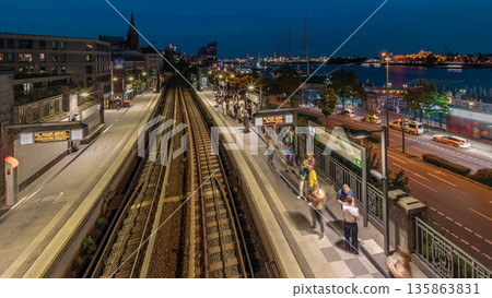 Aerial day to night timelapse of trains arriving at Landungsbrucken station in Hamburg, Germany. Aerial day to night timelapse of trains arriving at Landungsbrucken station in Hamburg, Germany. 135863831