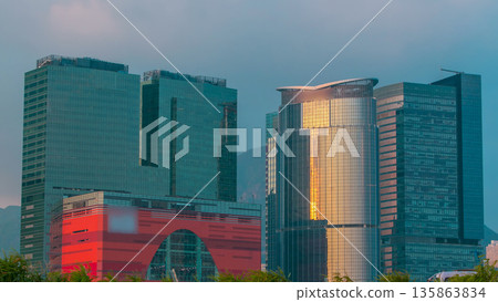 Sunset views of the city office towers and shopping mall from the port of Hong Kong timelapse. Sunset views of the city office towers and shopping mall from the port of Hong Kong timelapse. 135863834