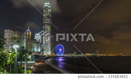 Skyscrapers night timelapse and Hong Kong Observation Wheel, which is the latest tourist attraction in the city. 135863852