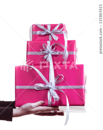 Female hands holding stack of pink gift boxes 135863915