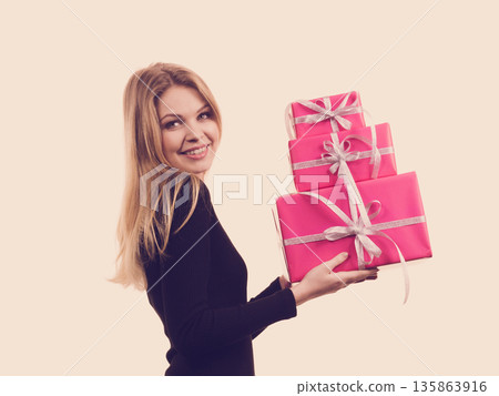 Girl holding stack of pink gift boxes 135863916
