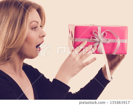 Surprised girl with pink gift box 135863917