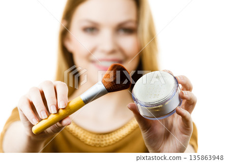 Smiling woman holding make up brush Smiling woman holding make up brush 135863948