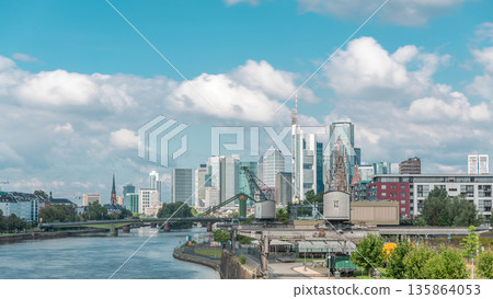 Hyperlapse of Frankfurt's Main Iron Footbridge against the financial district skyscrapers skyline on a sunny day with clouds timelapse. Frankfurt, Germany Hyperlapse of Frankfurt's Main Iron Footbridge against the financial district skyscrapers skyline on a sunny day with clouds timelapse. Frankfurt, Germany 135864053