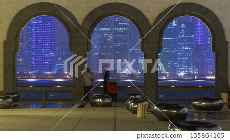 View at the heart of finance world of Doha night timelapse thought the three arches View at the heart of finance world of Doha night timelapse thought the three arches 135864105