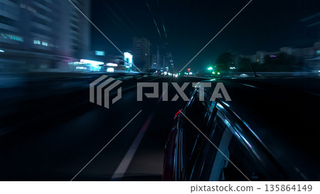 Drivelapse urban look from fast driving car at a night avenue in a city timelapse hyperlapse 135864149