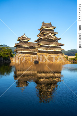 Matsumoto Castle reflecting in the water at sunset, Japan 135864655