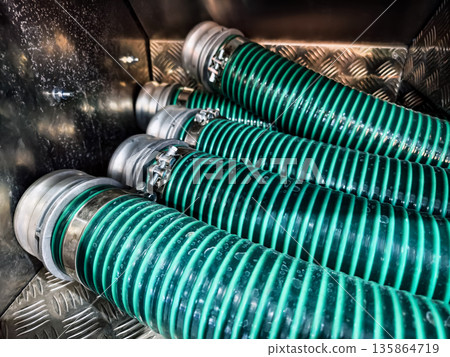 Hoses arranged in a storage area for use in industrial applications and maintenance tasks during daytime 135864719