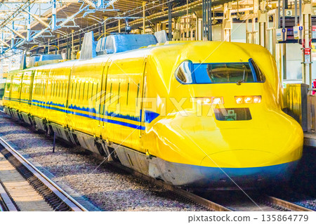 Yokohama cityscape in Japan: Towards a fortunate era. View of the yellow Shinkansen "Doctor Yellow" entering the Shin-Yokohama Station platform. Yokohama cityscape in Japan: Towards a fortunate era. View of the yellow Shinkansen "Doctor Yellow" entering the Shin-Yokohama Station platform. 135864779