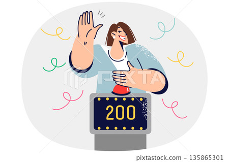 Woman participating in TV show with quiz game raises hand to press button, stands near point counter 135865301