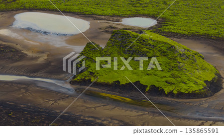 Aerial View of Moss Covered Volcanic Hill and Winding Streams in Iceland 135865591