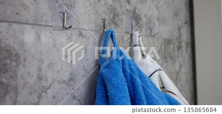 Terry bathrobes hang on hooks in the bathroom Terry bathrobes hang on hooks in the bathroom 135865684