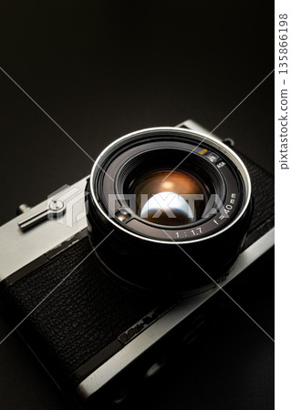Old film camera in spotlight against a dark background Old film camera in spotlight against a dark background 135866198