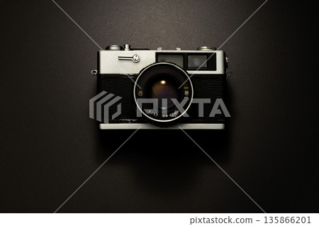 Old film camera in spotlight against a dark background Old film camera in spotlight against a dark background 135866201